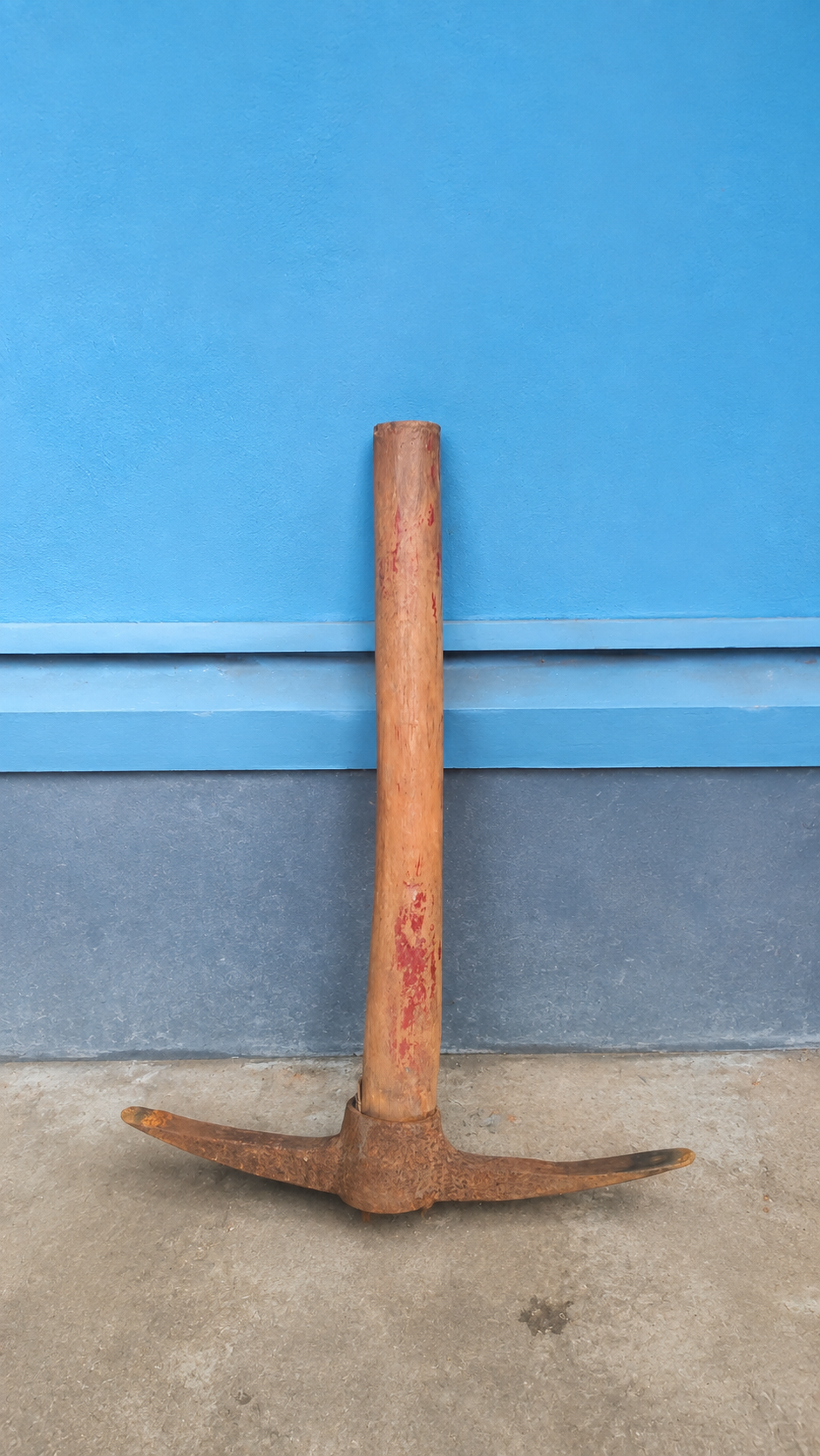 A pickaxe standing against a blue wall